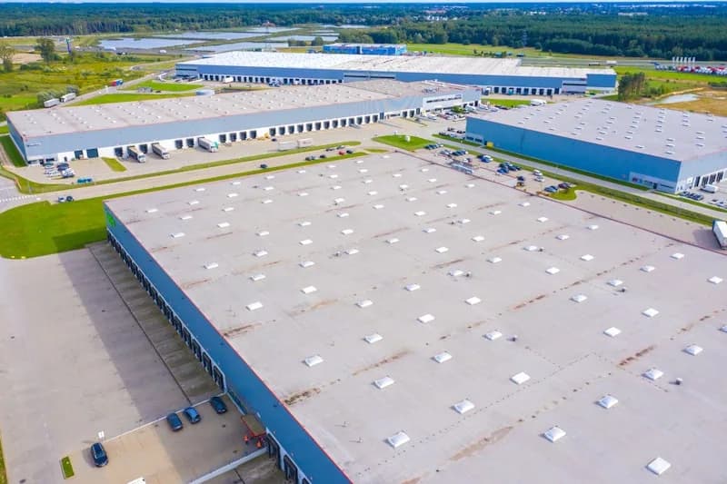 Naves de un parque industrial vistas desde arriba, con cubiertas amplias y equipos de ventilación sobre el techo