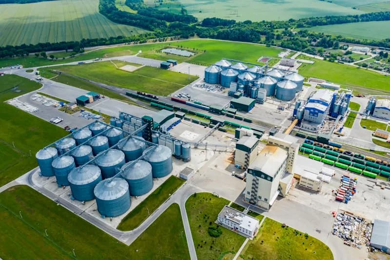 Vista aérea de una planta industrial con silos, tanques y edificios de proceso